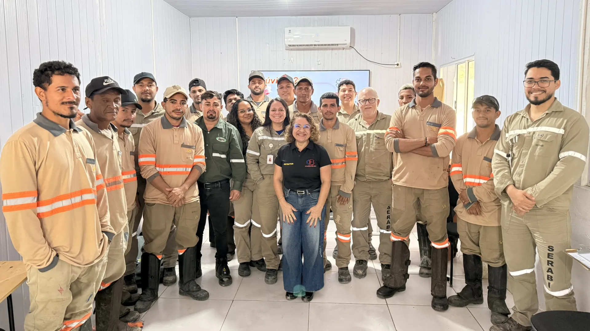 Equipe de uma empresa, em uniforme de trabalho, após o treinamento de primeiros socorros